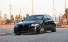 Черный BMW 5 series при выезде из города